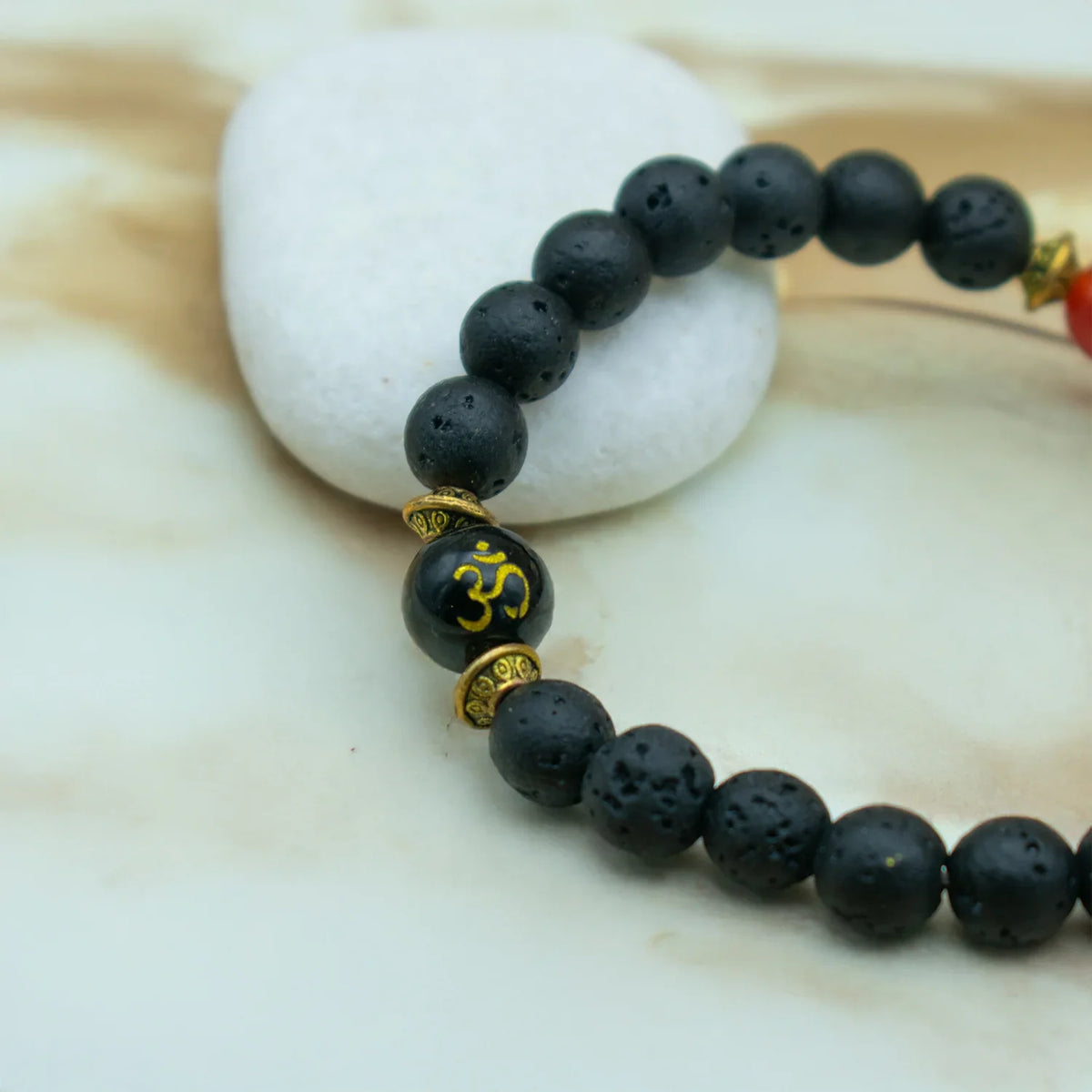 Stylish natural stone bracelets featuring black lava beads and decorative gold accents