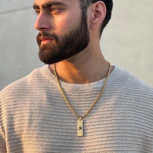 Devam 24K gold OM necklace worn by a man with a beard, showcasing its elegant design and spirituality