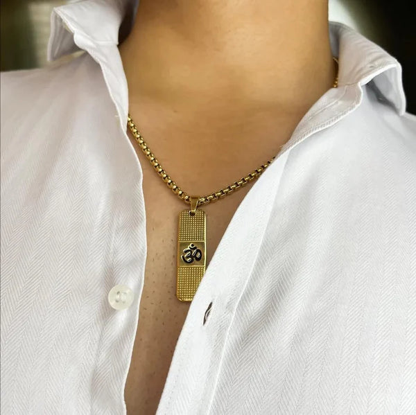 Elegant 24K gold OM necklace with a rectangular pendant worn on a white shirt